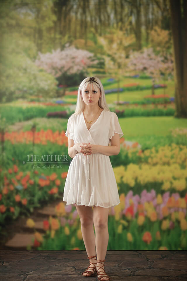 young woman in front of floral backdrop
