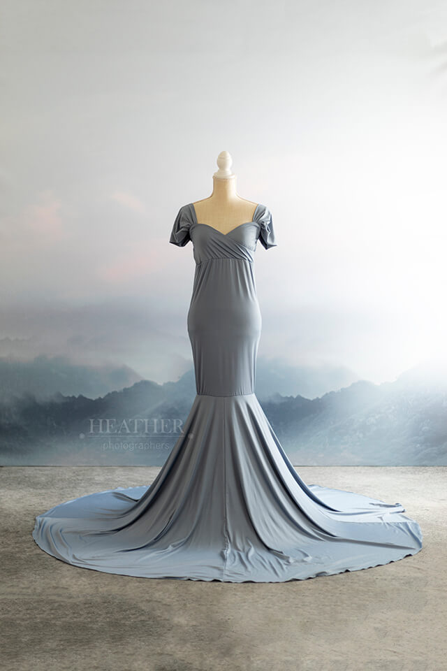 mannequin in light blue dress against mountain scape backdrop