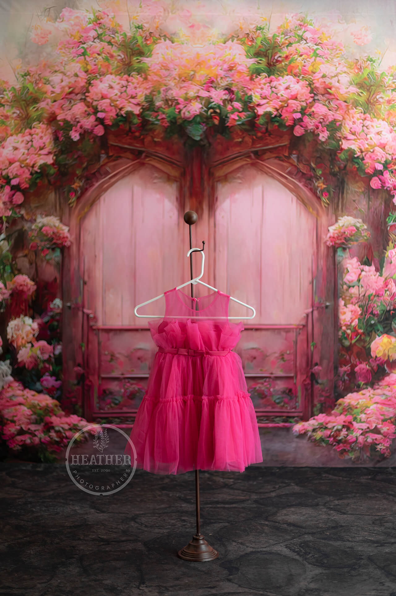 pink dress handing in front of floral backdrop